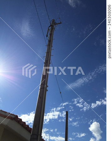 陽光照耀下，一根電線桿高高聳立在藍天之下。 140308006