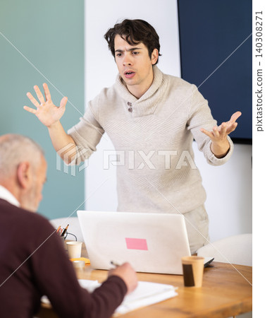 Quarrel between two managers - an elderly man and young man shout at each other, dissatisfied with their work Quarrel between two managers - an elderly man and young man shout at each other, dissatisfied with their work 140308271