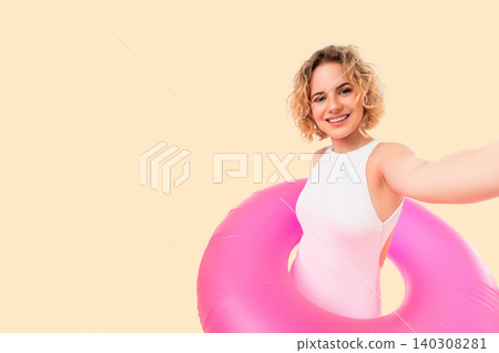 Woman enjoys summer vibes holding pink float. Joyful and confident lifestyle concept 140308281