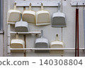 Well-used dustpans and cleaning tools hung neatly on the wall. 140308804