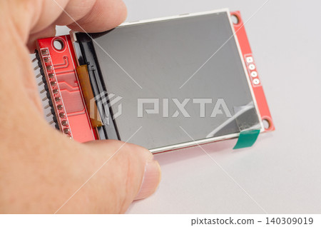Close-up of an OLED display for microcontroller devices held in a hand. 140309019