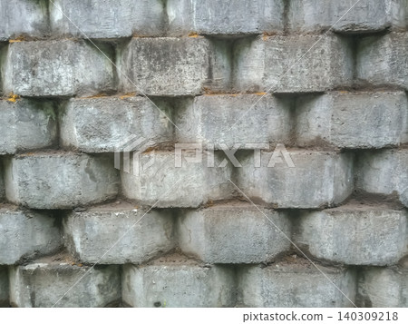 retaining wall made of interlocking, light grey concrete blocks. retaining wall made of interlocking, light grey concrete blocks. 140309218