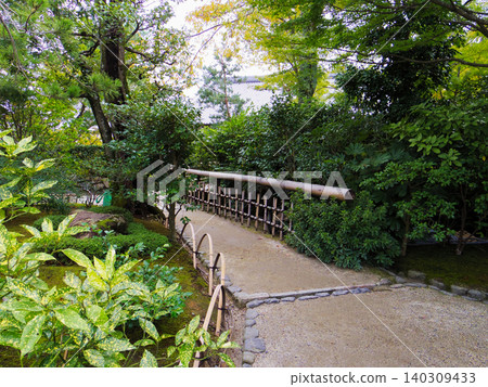 A quiet Japanese garden path lined with beautiful bamboo fences. 140309433