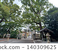 Stone lanterns and large trees line the left and right sides, and beyond the water basin and torii gate on the right is a road leading to a residential area with high-rise buildings. Stone lanterns and large trees line the left and right sides, and beyond the water basin and torii gate on the right is a road leading to a residential area with high-rise buildings. 140309625