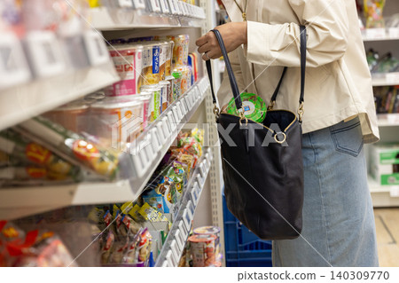 一起商店行竊案中,受害者將贓物藏在包包裡。 一起商店行竊案中,受害者將贓物藏在包包裡。 140309770
