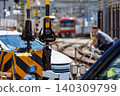 A scene of trains, cars, and bicycles crossing a railway crossing barrier. 140309799