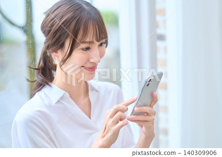 微笑的女人操作智慧型手機 微笑的女人操作智慧型手機 140309906