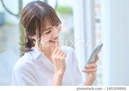 A woman thinking while watching a smartphone 140309908