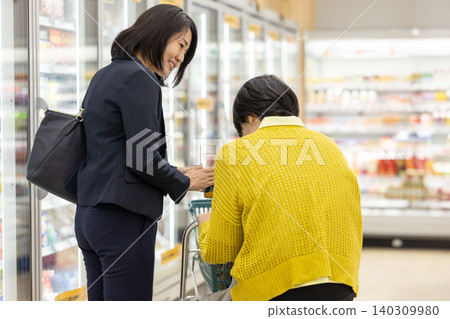一位女士陪同一位老人購物。 一位女士陪同一位老人購物。 140309980