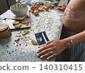 Pregnant woman baking cookies with ultrasound and flour 140310415