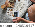 Pregnant woman making baby announcement with flour and cookies 140310417