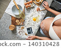 Pregnant woman baking cookies revealing pregnancy with sonogram 140310428