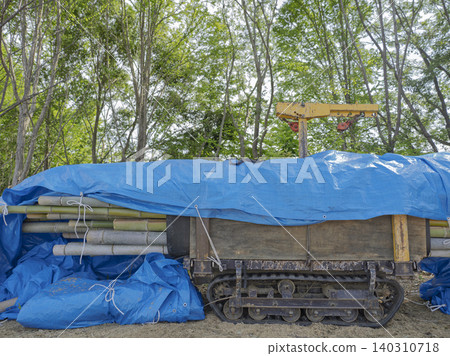 A blue materials transport truck rests on a forest road, waiting for its turn. A blue materials transport truck rests on a forest road, waiting for its turn. 140310718