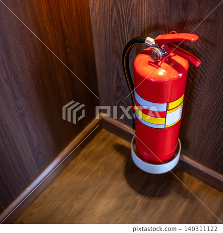 Red tank of fire extinguisher placed at the corner of wooden corridor Red tank of fire extinguisher placed at the corner of wooden corridor 140311122