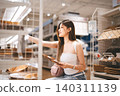 Asian woman shopping choosing plate product for home at indoors japan style warehouse superstore 140311139