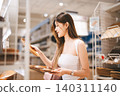 Asian woman shopping choosing plate product for home at indoors japan style warehouse superstore 140311140
