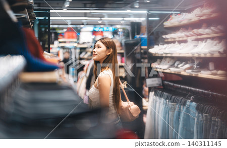 Young adult woman gen Z shopping choosing used clothing second hand shop fast fashion lifestyles Young adult woman gen Z shopping choosing used clothing second hand shop fast fashion lifestyles 140311145