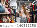 Young adult woman youth gen Z shopping choosing used purse bags second hand shop fast fashion 140311150