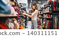 Young adult woman youth gen Z shopping choosing used purse bags second hand shop fast fashion 140311151