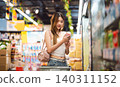 Young adult asian woman consumer choosing beverage drink at asia supermarket store choice buying 140311152