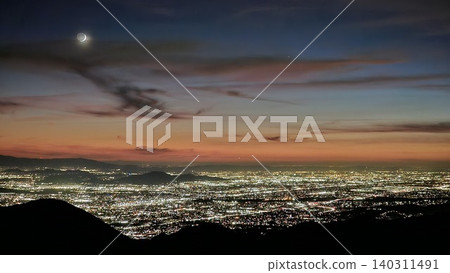 Beautiful Orange, Yellow and Blue Sunset with Moon over the City Lights of San Bernardino Beautiful Orange, Yellow and Blue Sunset with Moon over the City Lights of San Bernardino 140311491