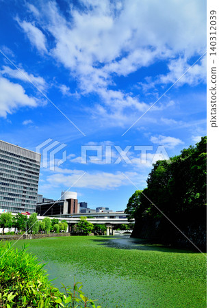 東京:美麗的清水護城河和周圍綠樹環繞的城市景觀。 東京:美麗的清水護城河和周圍綠樹環繞的城市景觀。 140312039