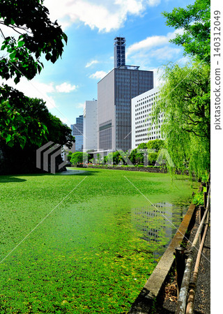 東京:美麗的清水護城河和周圍綠樹環繞的城市景觀。 東京:美麗的清水護城河和周圍綠樹環繞的城市景觀。 140312049