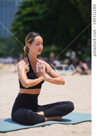 Woman meditating in yoga pose on beach with hands in prayer position Woman meditating in yoga pose on beach with hands in prayer position 140312268