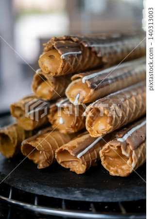 Waffles tube. Crispy cream cookie. Sweet pastry with caramel condensed milk filling appetizing topping stacked pile on black plate. Waffles tube. Crispy cream cookie. Sweet pastry with caramel condensed milk filling appetizing topping stacked pile on black plate. 140313003