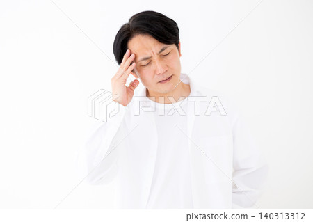 Portrait of a middle-aged man clutching his head in pain from a headache, against a white background. 140313312