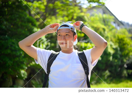 A man adjusting his hat 140313472