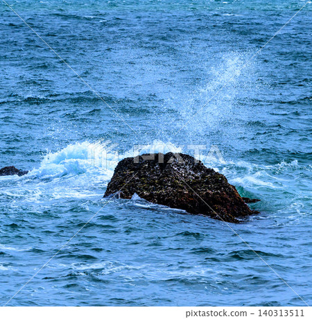 海面上漂浮的岩石濺起的水花 海面上漂浮的岩石濺起的水花 140313511