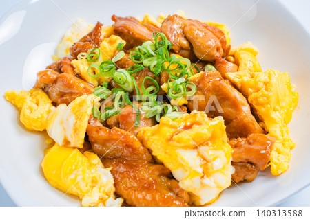 A photo of a Japanese-style dish of teriyaki chicken and egg stir-fried in a sweet and savory sauce. A photo of a Japanese-style dish of teriyaki chicken and egg stir-fried in a sweet and savory sauce. 140313588