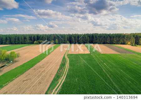 Aerial view of arable fields and plantation. Countryside, rural landscape with cloudy sky Aerial view of arable fields and plantation. Countryside, rural landscape with cloudy sky 140313694