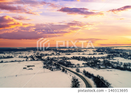Aerial evening view at countryside and snowy fields during sunset Aerial evening view at countryside and snowy fields during sunset 140313695