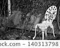 A white garden chair surrounded by ivy 140313798