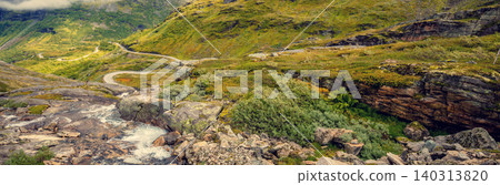 Autumn mountain landscape in Norway. Winding road in the mountains. Road 63 to Geiranger. View from Upper Blaafjeld Bridge Autumn mountain landscape in Norway. Winding road in the mountains. Road 63 to Geiranger. View from Upper Blaafjeld Bridge 140313820