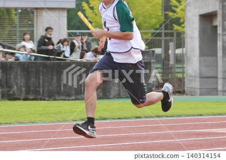 High school boys running in the track and field stadium High school boys running in the track and field stadium 140314154