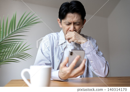 一位患有老花眼的中年男子,看不清智慧型手機螢幕。 一位患有老花眼的中年男子,看不清智慧型手機螢幕。 140314170