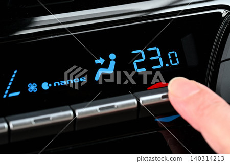 A woman's fingers adjusting the air conditioner temperature A woman's fingers adjusting the air conditioner temperature 140314213