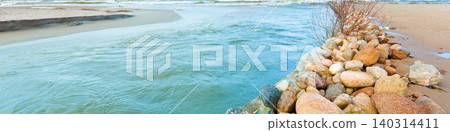 Delta in the daytime. Rocky bank of river. The river flows into the sea Delta in the daytime. Rocky bank of river. The river flows into the sea 140314411