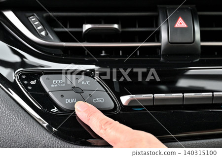 A woman's fingers turn on the air conditioner switch A woman's fingers turn on the air conditioner switch 140315100