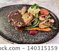 Close up view of delicious grilled chicken thigh steak with a rich gravy sauce and  vegetables on a textured black ceramic plate in a restaurant. 140315159