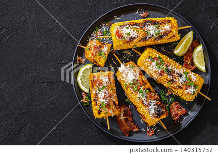 Grilled corn side dish is topped with bacon Grilled corn side dish is topped with bacon 140315732