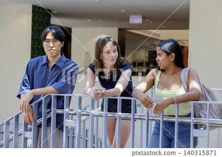 一名男大學生和一名女大學生在大學樓梯平台上交談。 一名男大學生和一名女大學生在大學樓梯平台上交談。 140315871