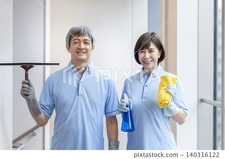Senior male and female cleaning staff smiling and looking at the camera. Senior male and female cleaning staff smiling and looking at the camera. 140316122