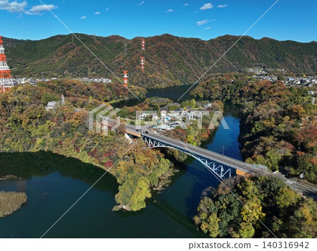一張空拍照片,展現了相模原市相模川上的鐵路橋以及秋天的樹葉。 一張空拍照片,展現了相模原市相模川上的鐵路橋以及秋天的樹葉。 140316942