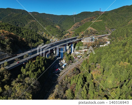 一張空拍照片顯示了橫跨相模原市山區的鐵路高架橋和鐵軌。 一張空拍照片顯示了橫跨相模原市山區的鐵路高架橋和鐵軌。 140316943