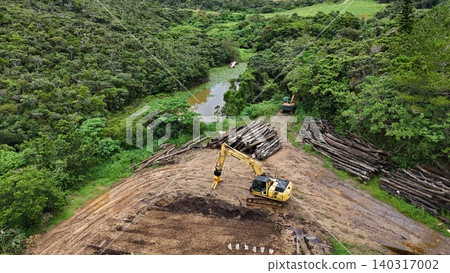 Aerial photograph capturing a tropical forest development site, heavy machinery, and logs. Aerial photograph capturing a tropical forest development site, heavy machinery, and logs. 140317002