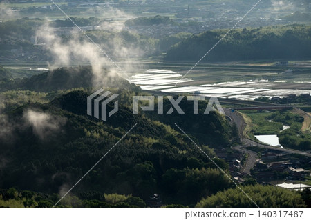 春天,鳥取縣米子市,群山環繞的住宅區,周圍是稻田。 春天,鳥取縣米子市,群山環繞的住宅區,周圍是稻田。 140317487